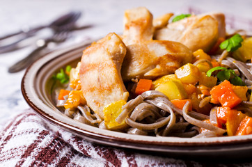 Dark pasta with vegetables and chicken.