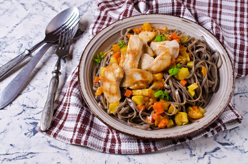Dark pasta with vegetables and chicken.