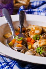 Dark pasta with vegetables and chicken.