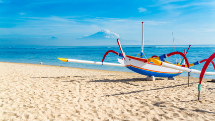 Pirogue de pêche traditionnelle indonésienne sur une belle plage de sable tropicale à Bali.