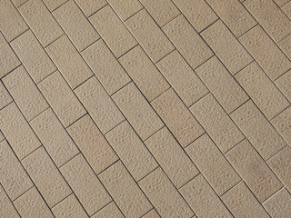 Rough textured stone tiles, exterior walkway, perspective view. Large square slab patterned flooring. Horizontal photo