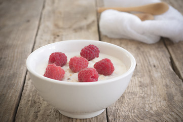 A healthy breakfast . Milk porridge with raspberries