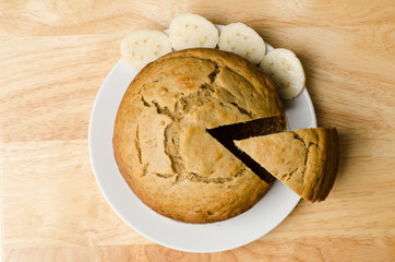 Homemade banana cake on white plate and wooden background