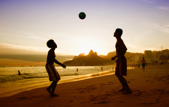 Two guys loves playing soccer at beach at Rio de Janeiro