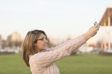 Profile of a teenage girl making a selfie photo