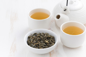 cups and teapot with fragrant green tea 