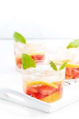 refreshing lemonade with strawberry and lemon on white tray
