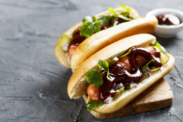 Hot dog with pickled cucumber, red onion and barbecue sauce