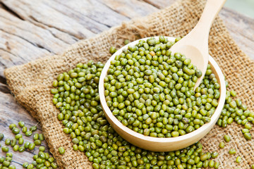 Mung bean with wooden spoon on linen fabric sack, rustic and organic farm concept
