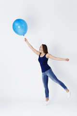 Fototapeta na wymiar Girl starts to float away with blue balloon