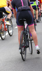 Naklejka na ściany i meble muscular legs of woman cyclist after the bicycle race in the cit