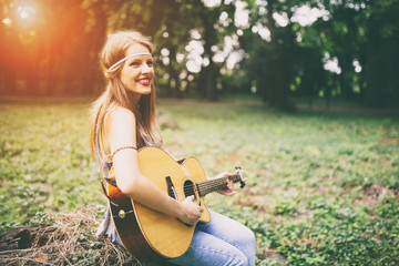 Fototapeta na wymiar Beautiful hippie girl playing guitar