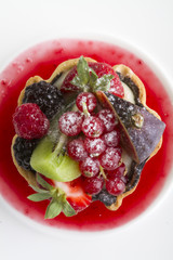 delicious fruit cake close up on white background. charming pie with fresh fruits on berry jam. 