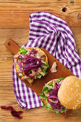 Burger with meat of duck with red onion and lettuce.