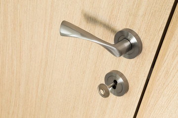 Door handle and key in a lock on a wooden door