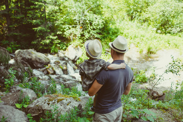 Father and his son looking to river in mountains, Bulgaria