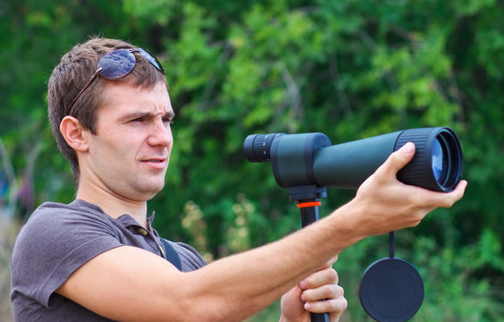 Man with spotting scope looks at the target. 