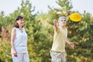 Paar Senioren spielt Frisbee im Sommer