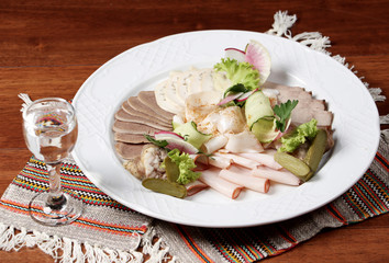 Plate of different meat cuts with vodka