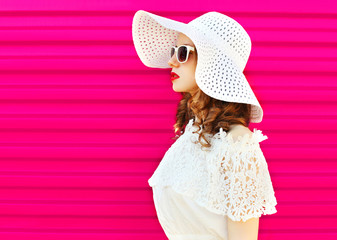 Woman in white summer straw hat over colorful pink background pr
