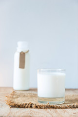 A glass of rustic milk and bottle of rustic milk with empty tag