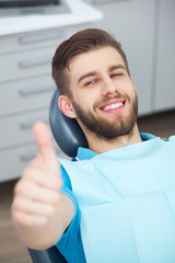 Portrait of happy patient in dental chair.