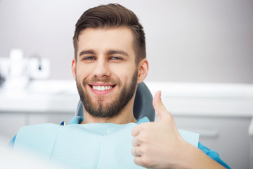 Portrait of happy patient in dental chair.