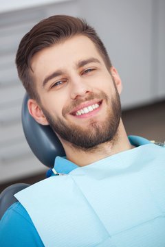 Portrait of happy patient in dental chair.