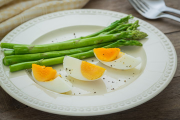 Boiled egg with asparagus on plate
