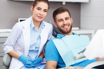 Obraz premium Portrait of a female dentist and young man in a dentist office.