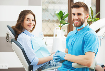 Portrait of a male dentist and young happy  female patient.