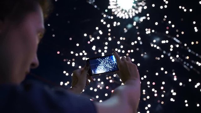 hands of man taking the photo to fireworks with the new smartphone