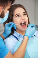 Young woman getting her teeth checked by a dentist.
