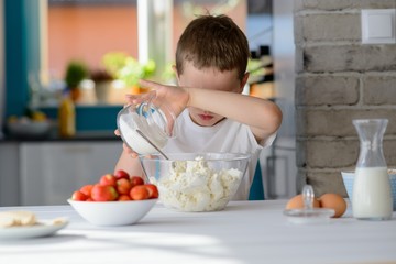 Child adding sugar to cottage cheese in a bowl.