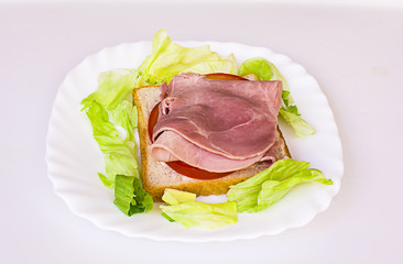 Sandwich with ham, tomato and green salad