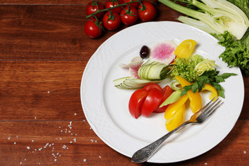 Vegetables on the white plate with wooden background
