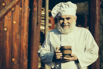 bearded cook with wooden cup
