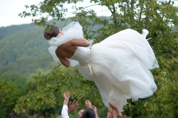 Men throw bride in air