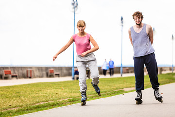 Active young people friends rollerskating outdoor.