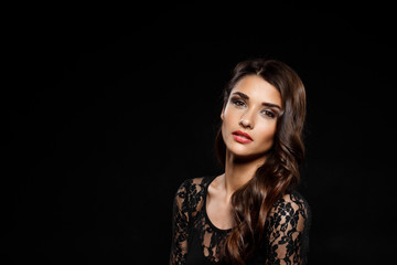 Fototapeta premium Portrait of beautiful girl in black dress over dark background