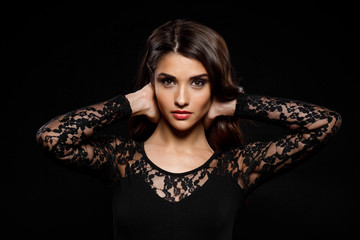 Portrait of beautiful girl in black dress over dark background