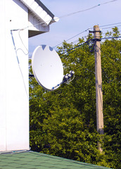 Small satellite antenna on the cottage home front on the backgro