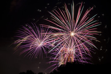 Red green and orange fireworks with sparkling stars.