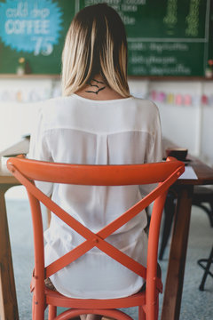 Young woman freelancer writing notes in cafe