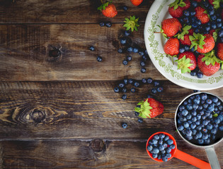 Background blueberries and strawberries in the plates. Top view