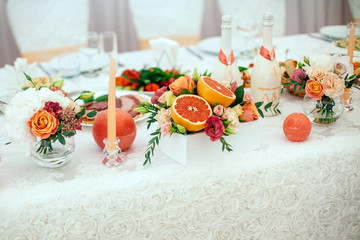 decoration of candles, grapefruit, flowers on the banquet table