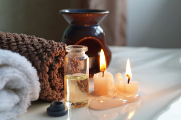 Fototapeta na wymiar Spa set with essential oils, towel and aromatic candles 