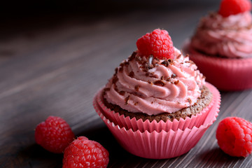Raspberry cupcakes sprinkled with chocolate on dark background