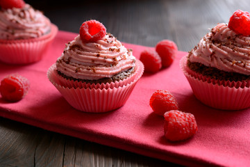 Raspberry cupcakes sprinkled with chocolate on dark background