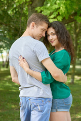 Obraz premium Romantic couple posing in city park, summer season, young people backside